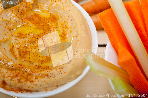 Image of fresh hummus dip with raw carrot and celery 