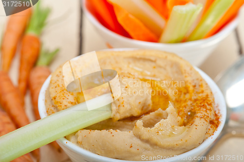 Image of fresh hummus dip with raw carrot and celery 