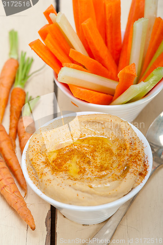 Image of fresh hummus dip with raw carrot and celery 