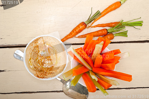 Image of fresh hummus dip with raw carrot and celery 