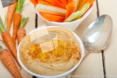 Image of fresh hummus dip with raw carrot and celery 