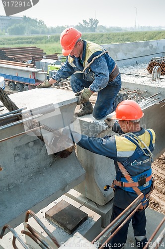 Image of Two workers busy on bridge construction