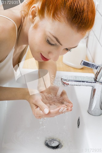 Image of Woman Washing her Face While Looking at the Camera