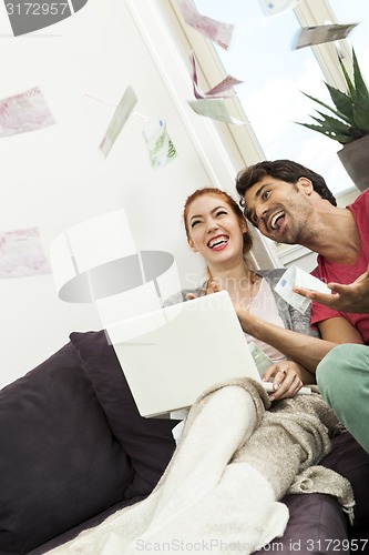 Image of Sitting Happy Couple Throwing Money in the Air