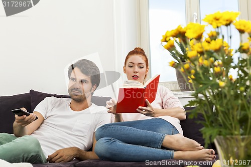 Image of Couple Resting on the Sofa at the Living Room