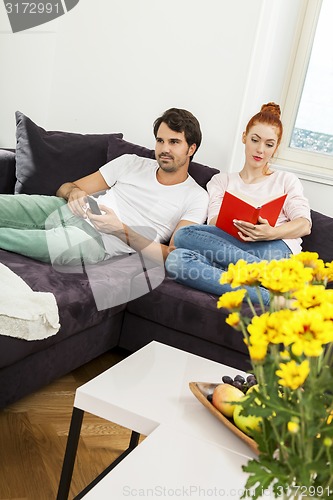 Image of Couple Resting on the Sofa at the Living Room