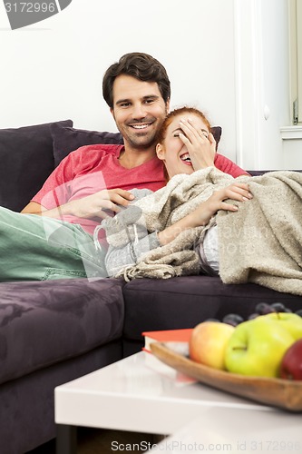 Image of Couple Resting on the Sofa at the Living Room