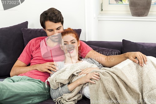 Image of Couple Resting on the Sofa at the Living Room