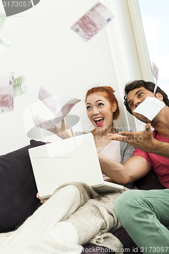 Image of Sitting Happy Couple Throwing Money in the Air