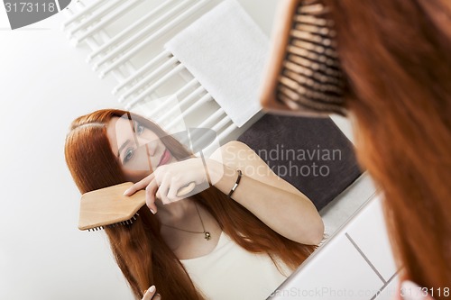 Image of Woman Brushing her Hair In Front a Mirror