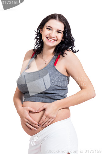 Image of Young pregnant woman making a heart gesture