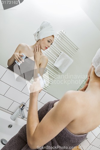 Image of Woman After Shower Applying Cream on her Face