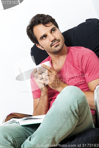 Image of Man Sitting on Chair with Book and a Drink