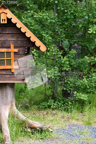 Image of log hut in the park on a background of trees