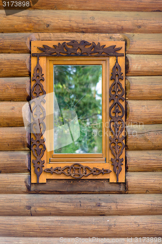 Image of window with wooden architraves in the wooden house