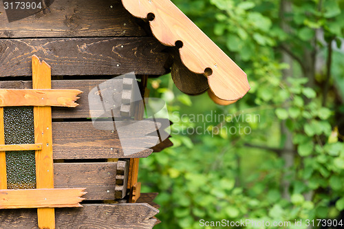 Image of log hut in the park on a background of trees