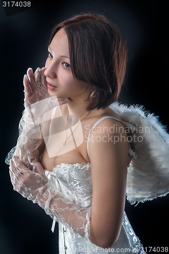 Image of Young woman in angel role whispers something
