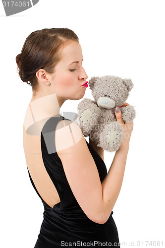 Image of attractive kissing brunette holding teddy bear