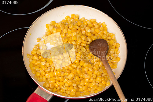 Image of cooking sweet conn with wooden spoon