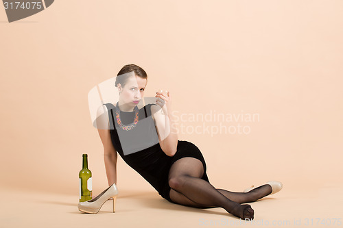 Image of beautiful young brunette woman holding a glass of white wine