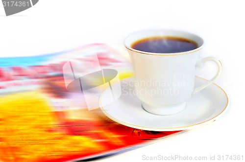 Image of A cup of hot coffee and a magazine 