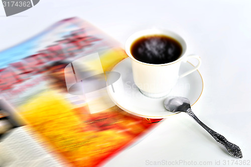 Image of A cup of hot coffee and a magazine 