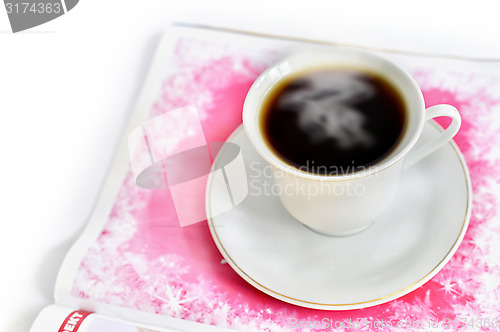 Image of A cup of hot coffee and a magazine