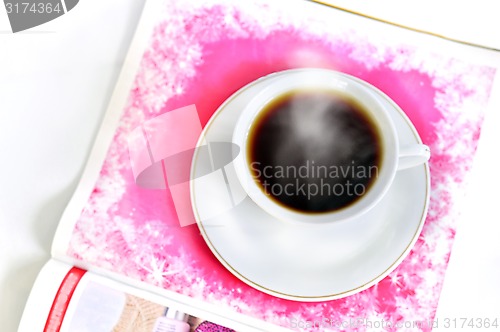 Image of A cup of hot coffee and a magazine