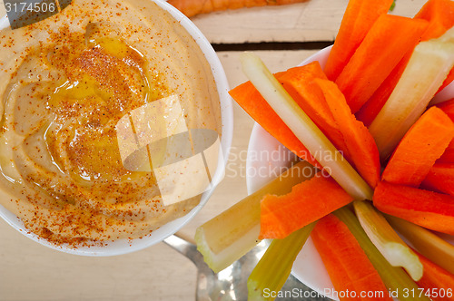 Image of fresh hummus dip with raw carrot and celery 