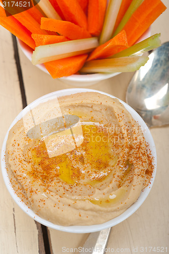 Image of fresh hummus dip with raw carrot and celery 