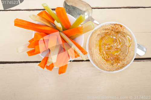 Image of fresh hummus dip with raw carrot and celery 