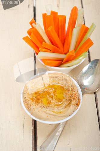 Image of fresh hummus dip with raw carrot and celery 