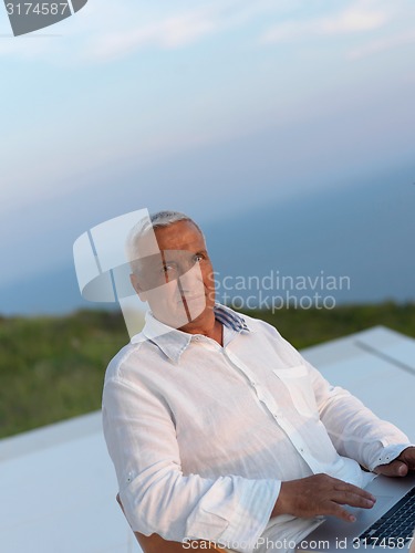 Image of relaxed senior man on balcony