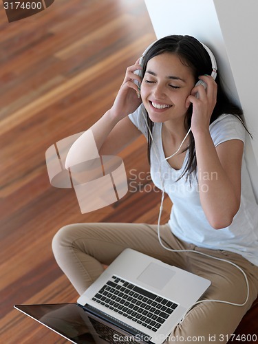 Image of relaxed young woman at home working on laptop computer