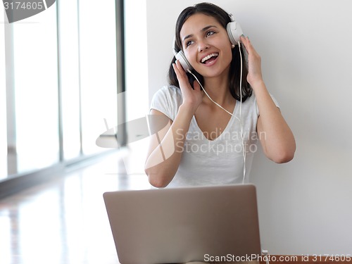 Image of relaxed young woman at home working on laptop computer