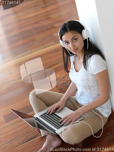 Image of relaxed young woman at home working on laptop computer