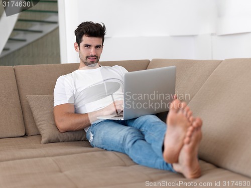 Image of Man Relaxing On Sofa With Laptop