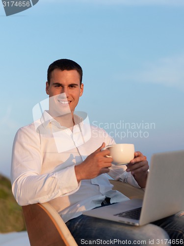 Image of relaxed young man at home on balcony