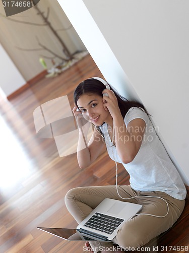 Image of relaxed young woman at home working on laptop computer