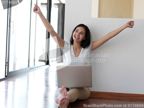 Image of relaxed young woman at home working on laptop computer