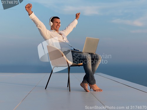 Image of relaxed young man at home on balcony