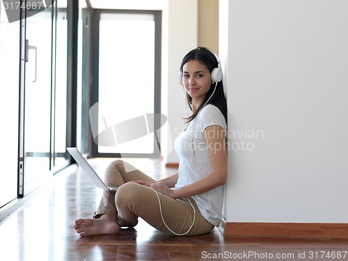 Image of relaxed young woman at home working on laptop computer