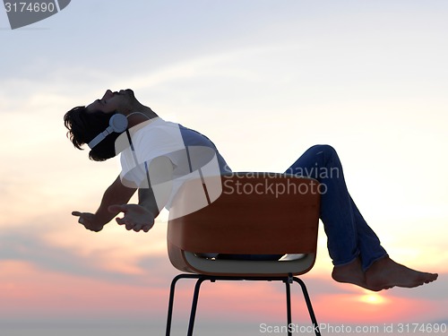 Image of relaxed young man at home on balcony