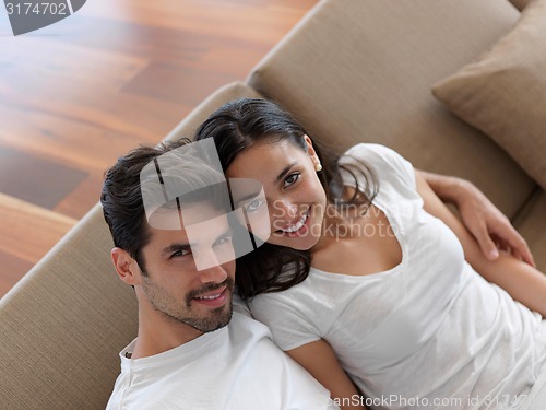 Image of relaxed young couple working on laptop computer at home