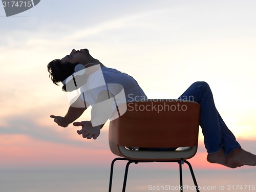 Image of relaxed young man at home on balcony