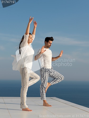 Image of young couple practicing yoga