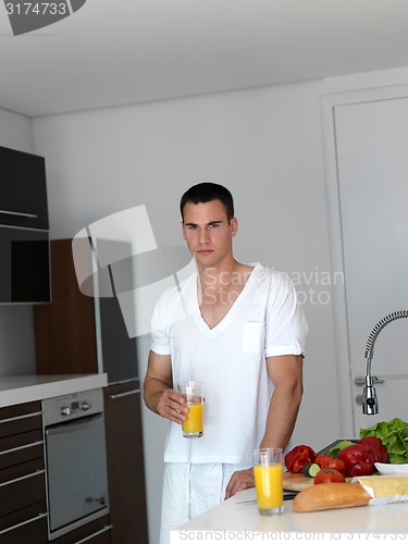 Image of man cooking at home preparing salad in kitchen