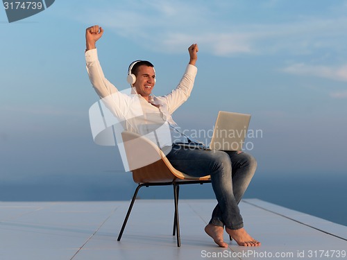Image of relaxed young man at home on balcony