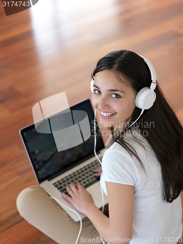 Image of relaxed young woman at home working on laptop computer