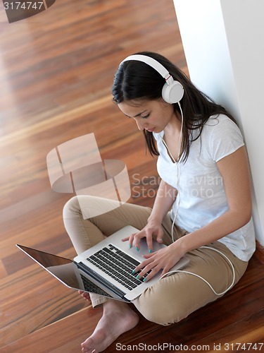 Image of relaxed young woman at home working on laptop computer